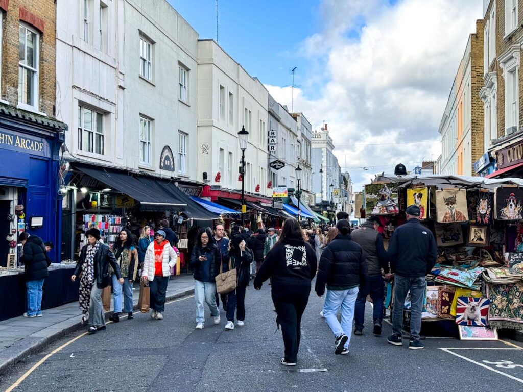 Portobello Market in Notting Hill with many people browsing shops