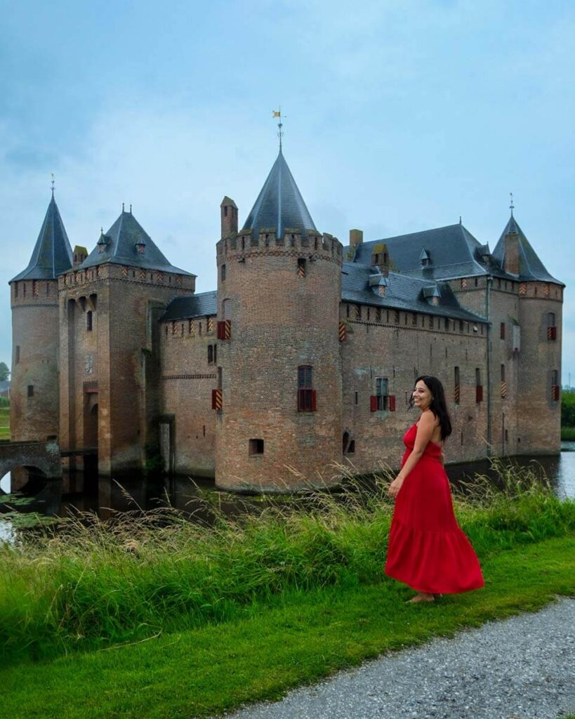 jackie in a red dress outside of muiden castle one of the best things to do outside of amsterdam
