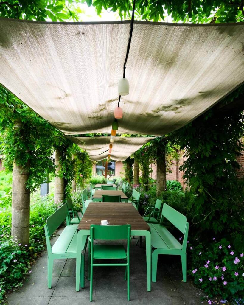 a green tavke abd chairs outside in a garden singer larden museum netherlands