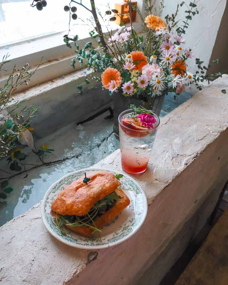Sandwich and drink by window.