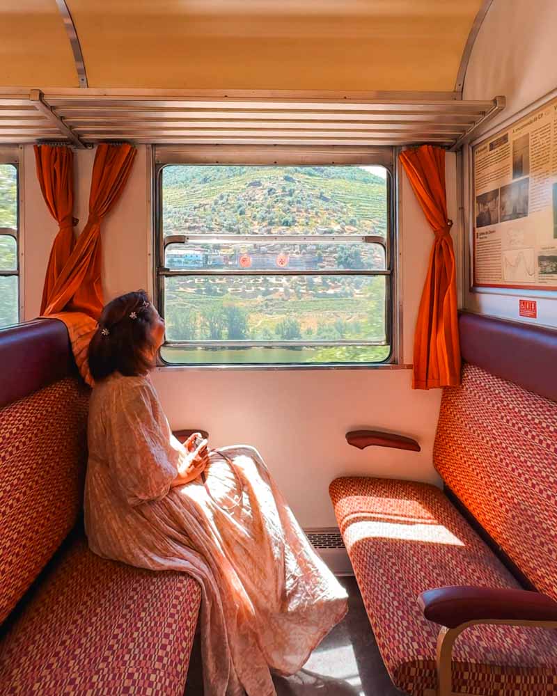 female looking out of the train at the views of douro valley